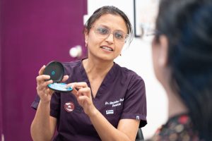 Dr Umisha Patel showing a patient a clear aligner and mirror